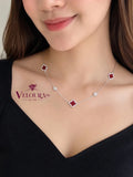 Station necklace in 925 silver with red carnelian clovers spaced along the chain, shown on the neck