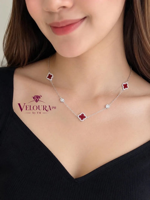 Station necklace in 925 silver with red carnelian clovers spaced along the chain, shown on the neck