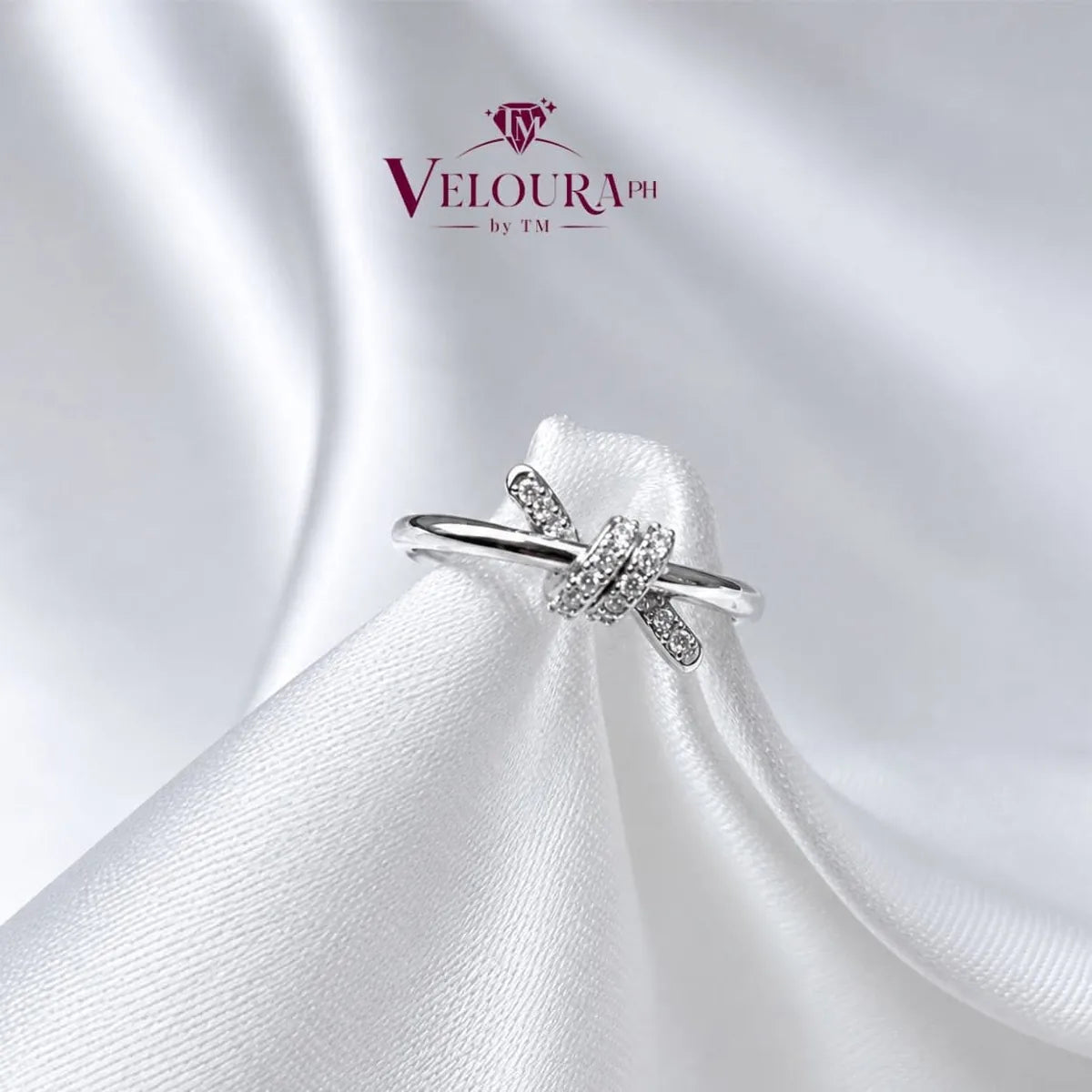 Infinity twist solitaire ring in 925 silver with a moissanite centre and crossover band